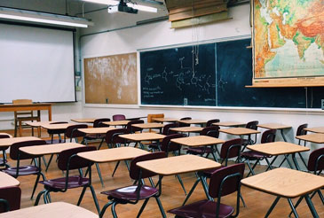 Empty classroom with student desks and chalkboards