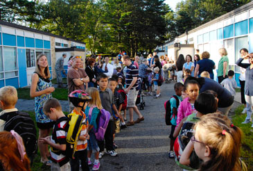 Group of kids with teachers outside of a school